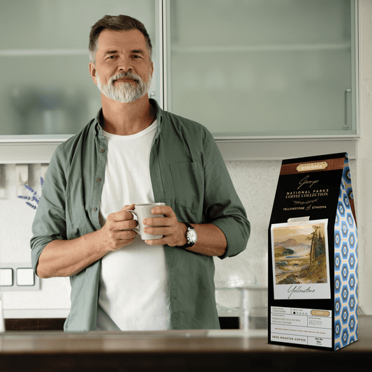 Single-origin specialty coffee from Ethiopia Sidama in collectible GEORGE National Parks Collection packaging by Official Fellow Citizen. Scene of man holding cup of coffee in background. - Certified by Mintall.