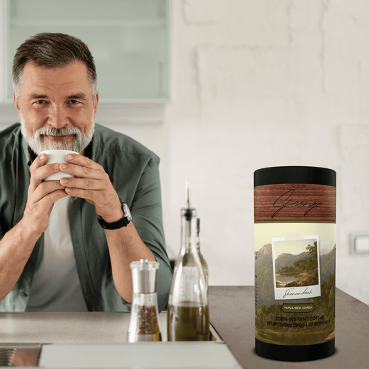Specialty instant coffee from Papua New Guinea in collectible GEORGE National Parks Collection tube packaging by Official Fellow Citizen. Man holding cup of coffee. - Certified by Mintall.