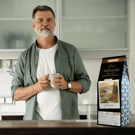 Single-origin specialty coffee from Ethiopia Sidama in collectible GEORGE National Parks Collection packaging by Official Fellow Citizen. Scene of man holding cup of coffee in background.